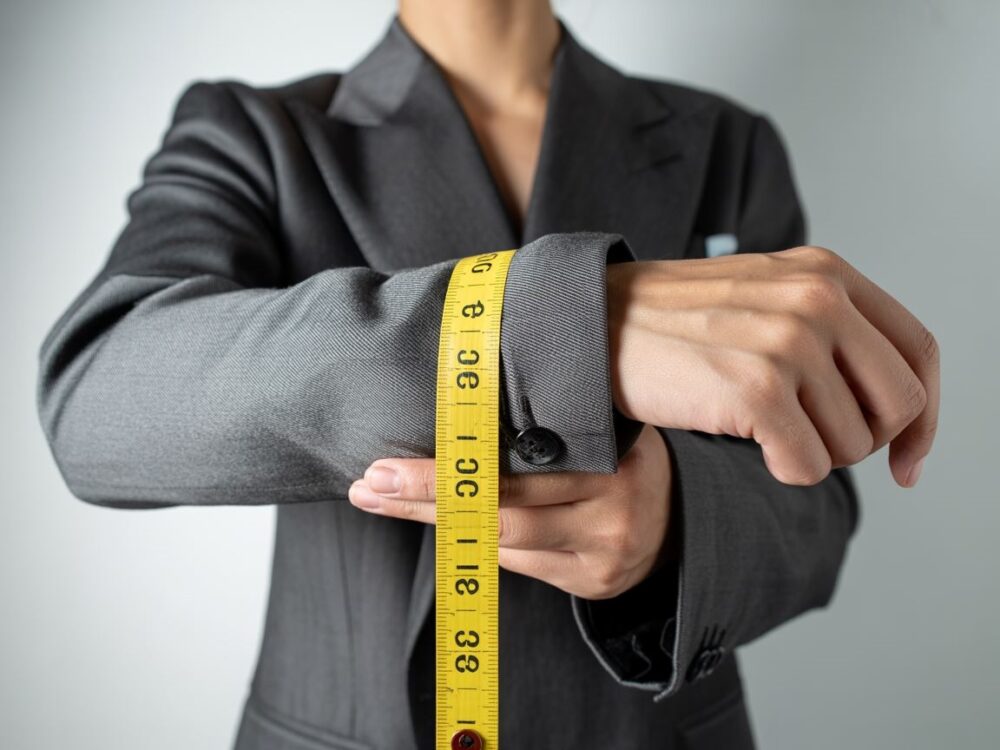 ręka z miarką przy rękawie